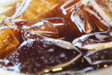Close-up pictures of ice floating on Americano coffee.
