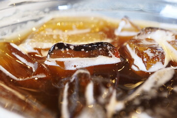 Close-up pictures of ice floating on Americano coffee.