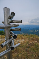 silver-colored metal signpost in the mountains close-up across aerial mountains view. Adventure, travel lifestyle. Pietra di Bismantova, Italy