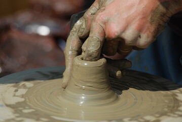  hands of a potter, creating an earthen jar on the circle Bistrita,Romania