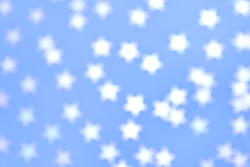 Confetti stars on blue background, out of focus.