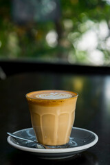 cup of hot latte art coffee on wood table in morning sun light, relax time