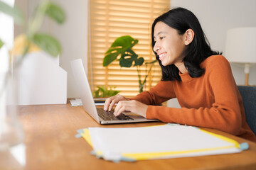 Asian girl student learning online via the internet with tutor on laptop