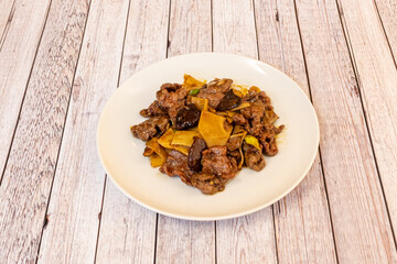 Chinese recipe of stewed beef with bamboo and mushrooms on white plate