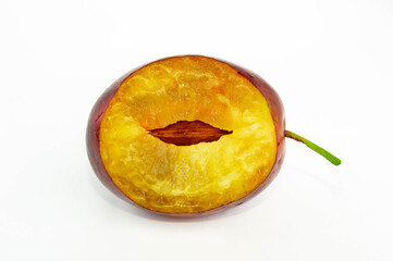 Bitten plum with a bone on a white background. Macro, freshness
