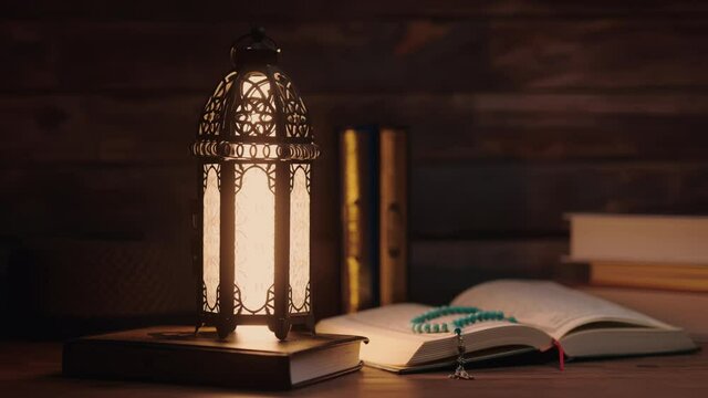 Islamic concept - The Holy Al Quran with written Arabic calligraphy meaning of Al Quran and a beautiful Arabian lamp, Arabic word translation : The Holy Al Quran (holy book of Muslim)