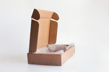 Open cardboard box with bubble wrap inside on a white background. Side photo.