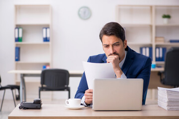 Young male employee and too much work in the office
