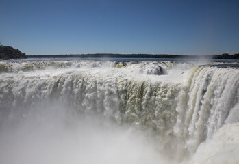 Nature's power. View of the Iguazu waterfalls and river, seen from Garganta del Diablo, in Misiones, Argentina. The amazing falls and falling white water beautiful texture, mist and splash.