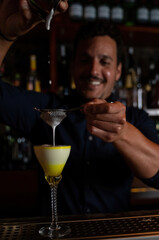 Barman adding egg white to cocktail