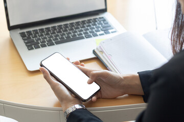 Woman's hands holding or using smartphone with two hands. Smartphone with white blank on screen, Cellphone mockup.