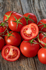 fresh ripe bunch tomatoes on wood background. Close up