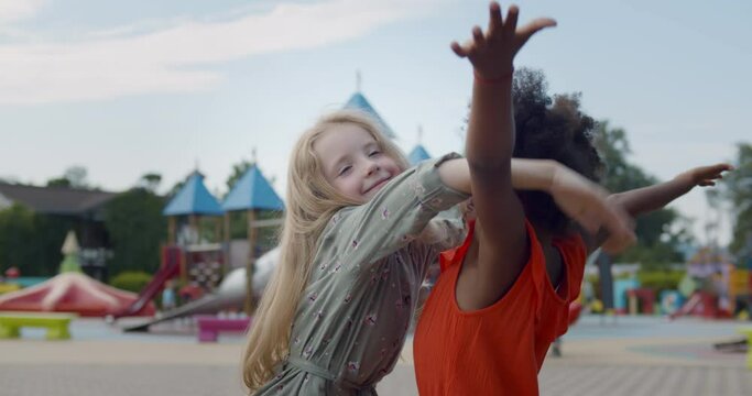Diverse happy kids hugging on children playground