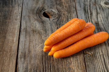 fresh ripe carrots on wood background. Copy space