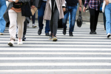 Busy city street people on zebra crossing, blured background. Pedestrian crossing through a busy street