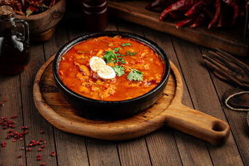 Georgian chicken chakhokhbili with tomato sauce on wooden background