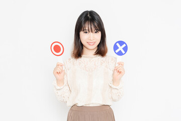 OKとNGのプラカードを持って立っている女性
