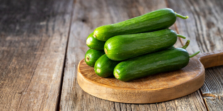 fresh ripe cucumbers on wood background. Copy space