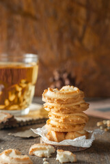 butter cookies stacked and a glass of tea on wood table background