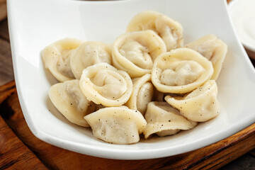 Closeup on boiled russian pelmeni mini dumplings with meat filling