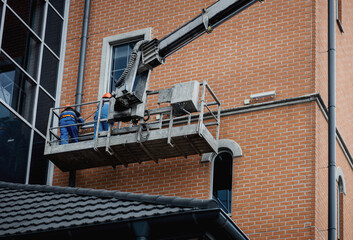 Workers in hardhat repair facade