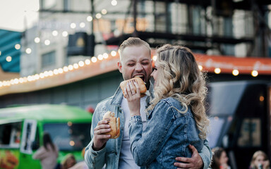 Couple eating sandwich outdoors