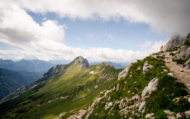 Naklejka premium The high Plateau of Montasio with green pastures in summer and Julian Alps (Jof di Montasio). Udine, Friuli Venezia Giulia, Italy, Europe