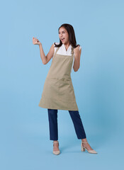 Portrait of service minded asian woman employee studio shot on blue background