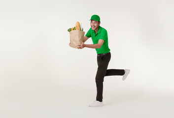 Asian delivery man wearing in green uniform holding fresh food paper bag and running isolated over...