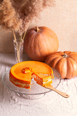 Homemade cottage cheese and pumpkin striped casserole with poppy seeds and orange on the table with...
