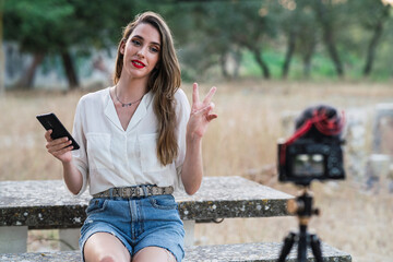 Chica joven frente a cámara creando contenido audiovisual