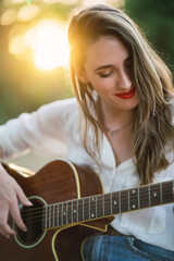 Fototapeta premium Chica joven en parque natural con guitarra acustica