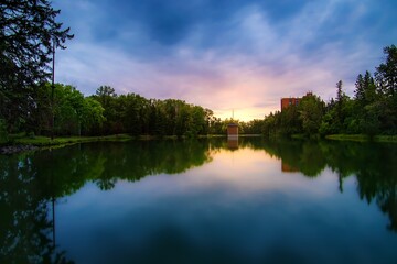Fototapeta na wymiar Sunrise Glowing Over A Summer Park Lake