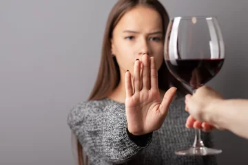 Foto op Canvas refuse alcohol, stop liquor, teenager shows a sign of rejection of wine with her hand © yta