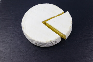 Brie cheese on a black slate background