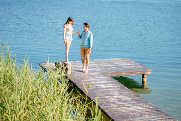 Lovely couple on wooden bridge at summer sunny day. Summer holidays, love, relaxing concept.