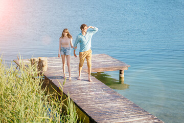 Fototapeta premium Lovely couple on wooden bridge at summer sunny day.