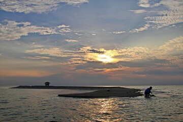 Naklejka premium Sunset on a Sandbar with a Small Hut