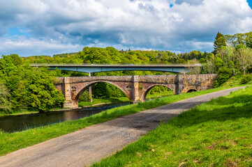 Fototapeta na wymiar A view towards the Medieval bridge and modern road bridge at Leaderfoot in Scotland on a summers day 