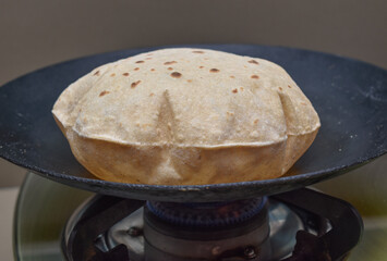 Indian soft phulka Chapati (roti) on non stick tawa also known as tortilla.