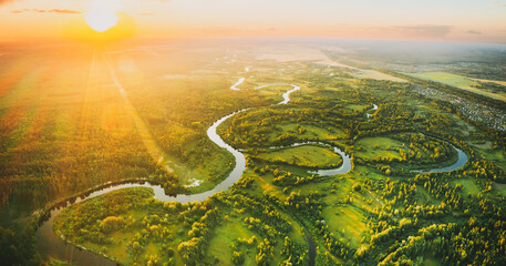 Aerial View. Beautiful Sunset Sun Sunshine Above Green Forest, Meadow And River Landscape In Sunny...