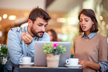 Couple looking on laptop at cafe