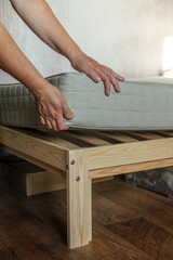 A woman puts a mattress on the bed or postpones the cleaning process