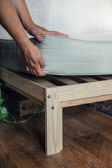 A woman puts a mattress on the bed or postpones the cleaning process