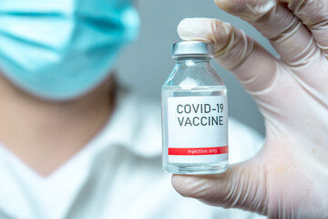 A little single glass bottle vial of new Covid-19 vaccine. Healthcare concept vaccination injection treatment.