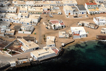 Fototapeta premium Fotografía aérea de la costa y pueblo de la Caleta del Sebo en la isla de La Graciosa, Canarias
