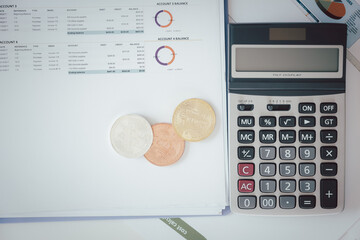 Various golden and silver of Cryptocurrency and calculator on chart or graph paper.