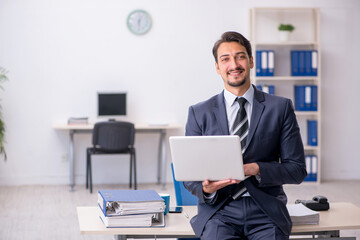 Young male employee sitting at workplace