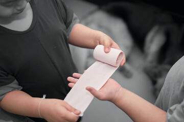elastic roll gauze bandage hold in hand with adhesive for first aid compress care for accident...