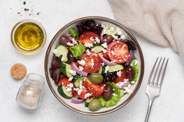 Greek salad with feta cheese and fresh vegetables on white background